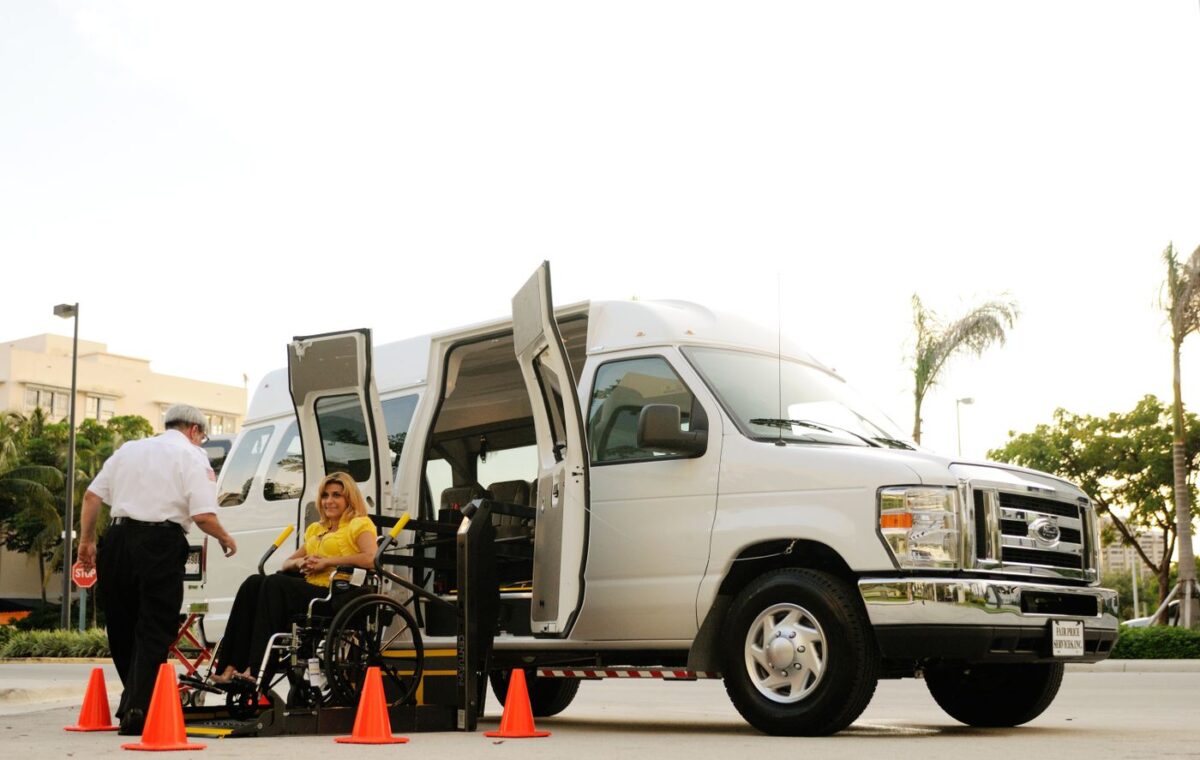 Pessoa em cadeira de rodas utiliza plataforma elevatória para embarcar em uma van