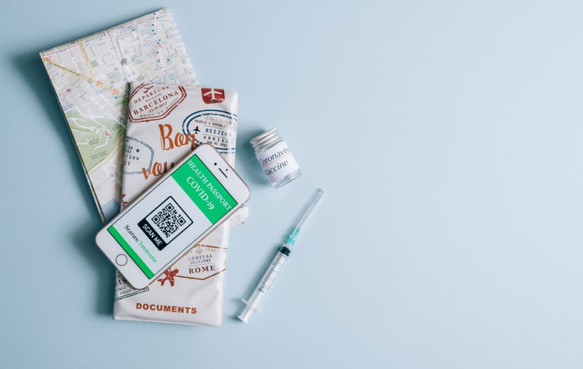 Celular, seringa e documentos sobre mapa em preparação para viagem
