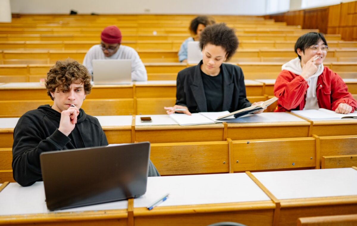 Estudantes universitários com livros e notebooks em uma sala de aula