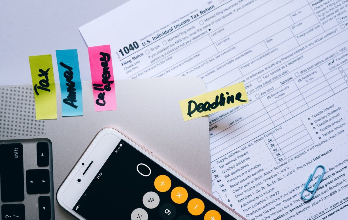 Celular, calculadora e documentos financeiros organizados sobre uma mesa
