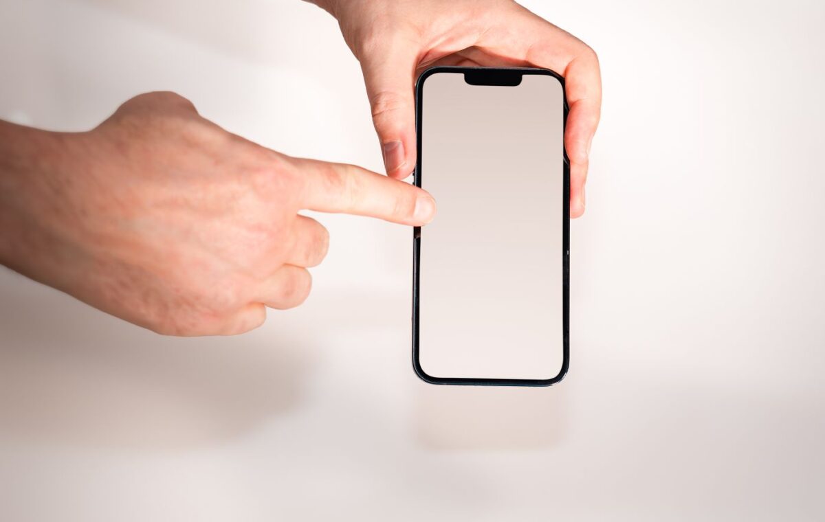 Pessoa toca a tela de um smartphone enquanto segura o aparelho
