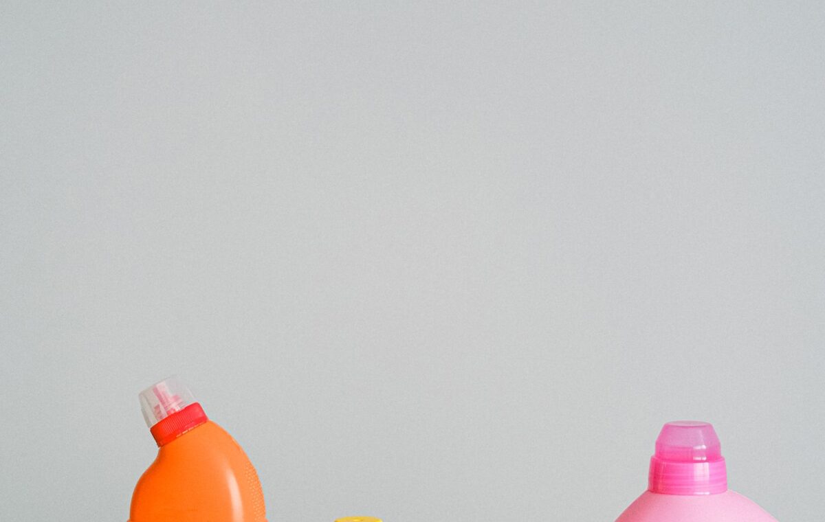 Frascos coloridos de produtos de limpeza organizados sobre uma superfície branca