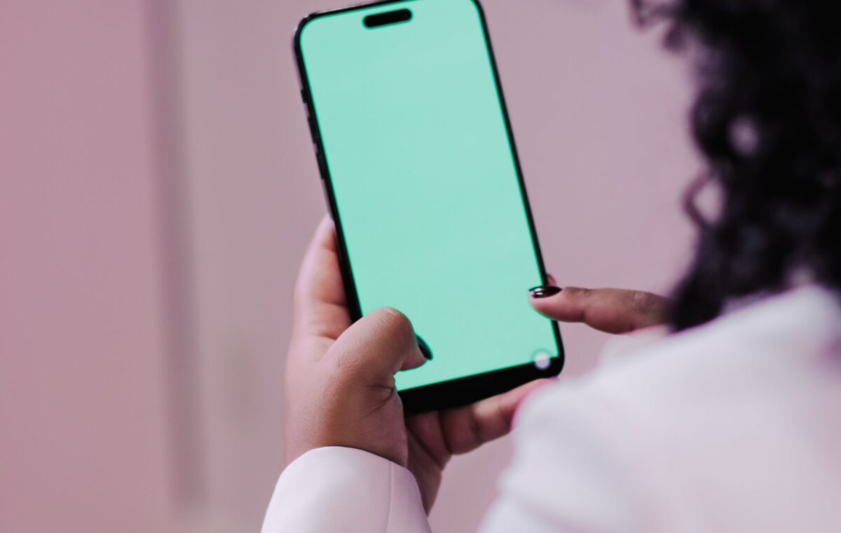 Pessoa segura telefone celular com a tela vazia em ambiente interno