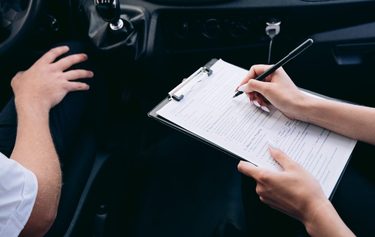Pessoa preenche prancheta no interior de um carro